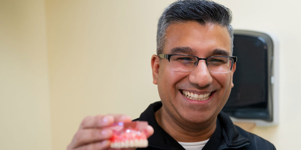 Doctor holding up a model of teeth