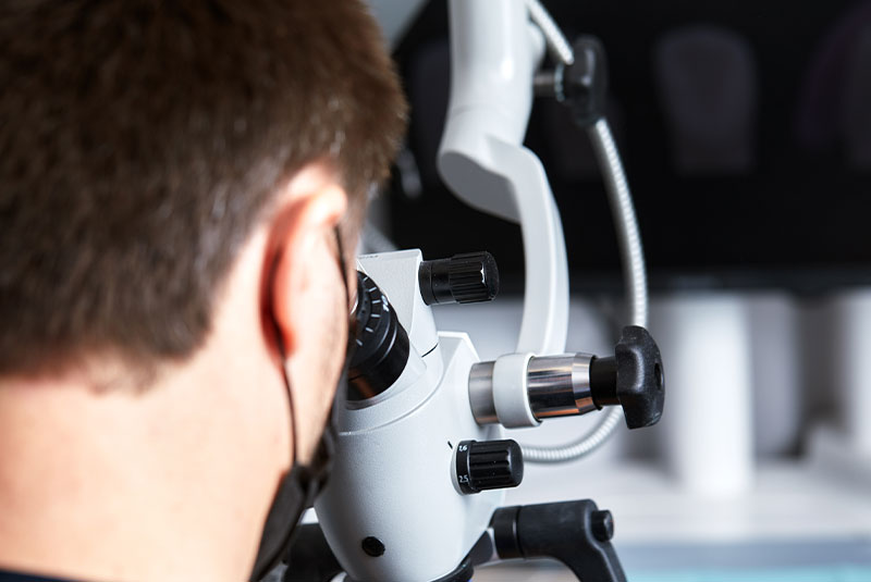 doctor looking under microscope