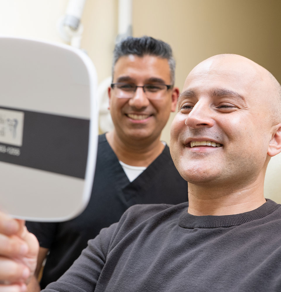 Patient and doctor smiling into mirror