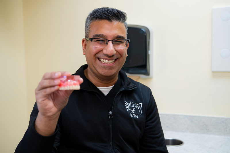 Doctor holding model of dental implants